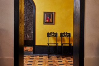 View of two chairs through walkway in lobby