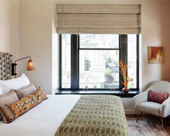 signature Proper bed, dressed in Fili D’oro fine linens and view of the city