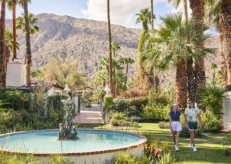 Two girls walking close to a fountain