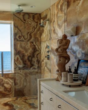 Ocean front bathroom with marble walls and walk-in shower